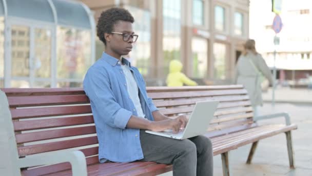 Кашель Африканский Человек Помощью Ноутбука Сидя Открытом Воздухе Скамейке — стоковое видео
