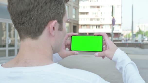 Casual Man Holding Horizontal Smartphone Green Screen Outdoor — Vídeo de Stock