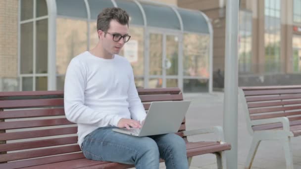 Casual Man Celebrating Success Laptop While Sitting Outdoor Bench — стоковое видео