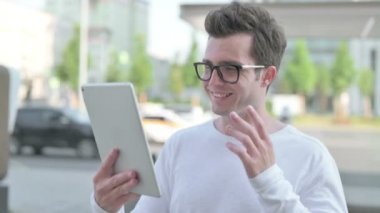 Video Call on Tablet by Casual Man Outdoor