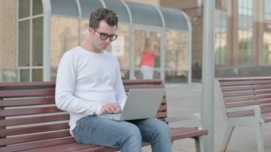Busy Casual Man Using Laptop Sitting Outdoor on Bench