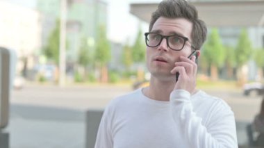 Casual Man Talking on Phone while Standing Outdoor
