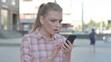 Upset Casual Woman Reacting to Loss on Smartphone Outdoor