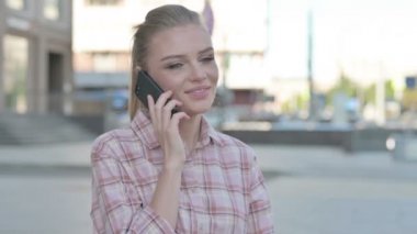 Casual Woman Talking on Phone while Standing Outdoor