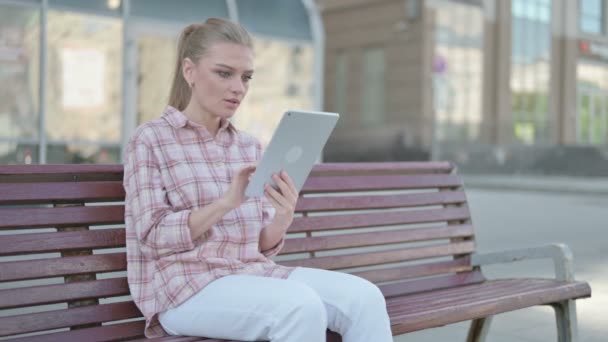 Casual Woman Celebrating Online Win Tablet While Sitting Outdoor Bench — Vídeo de Stock