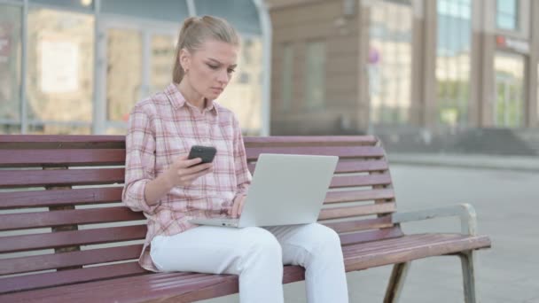 Casual Woman Using Smartphone Laptop While Sitting Outdoor Bench — Stock video