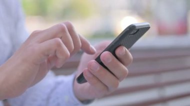 Male Hand Browsing Internet on Smartphone Outdoor