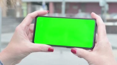 Close Up of Senior Old Woman Using Smartphone with Green Screen Outdoor