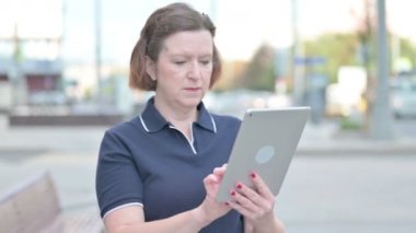 Senior Old Woman Celebrating Success on Tablet Outdoor