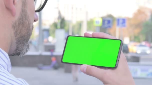 Close Adult Man Holding Horizontal Smartphone Green Screen Outdoor — Stok Video