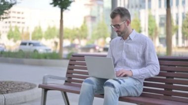Agree Adult Man Shaking Head in Approval while Sitting on Bench Outdoor