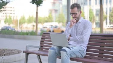Thinking Adult Man Using Laptop while Sitting Outdoor on Bench