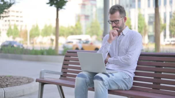 Thinking Adult Man Using Laptop While Sitting Outdoor Bench — Stockvideo