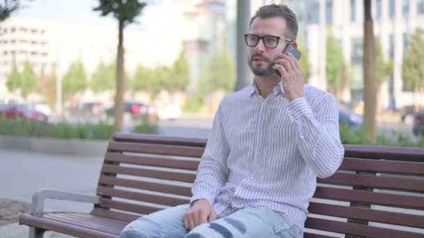 Adult Man Talking Phone While Sitting Outdoor Bench — Stockvideo