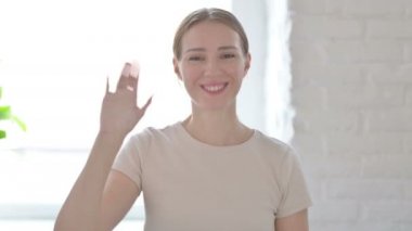 Young Woman Waving Hand to Say Hello