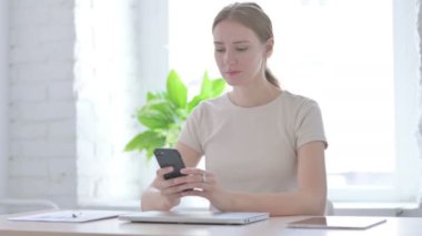 Successful Young Woman Celebrating Win on Smartphone