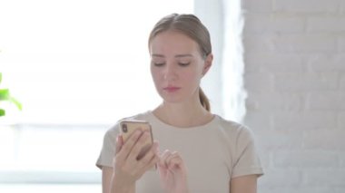 Young Woman using Smartphone for Browsing Internet
