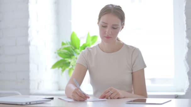 Νεαρή Γυναίκα Που Γράφει Χαρτί Στο Γραφείο — Αρχείο Βίντεο