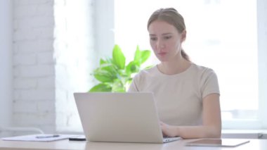 Young Woman Reacting to Financial Loss While using Laptop 