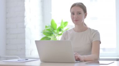 Laptop kullanırken Telefonda Konuşan Genç Kadın