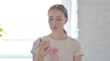 Excited Young Woman Celebrating Win on Smartphone