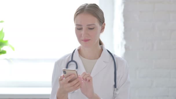 Female Doctor Using Smartphone Browsing Internet — Video Stock