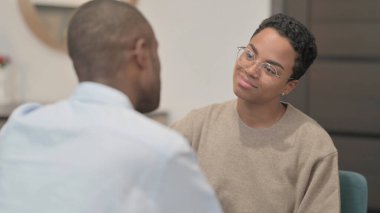 The Happy Young Couple having Conversation while Sitting on Sofa, Rear View