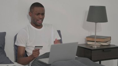 The African Man with Unsuccessful Online Payment on Laptop, Sitting in Bed