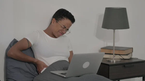 Young African Woman Having Back Pain While Using Laptop Bed — 스톡 사진
