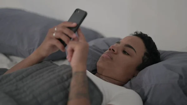 Close African Woman Using Smartphone While Laying Bed — Fotografia de Stock