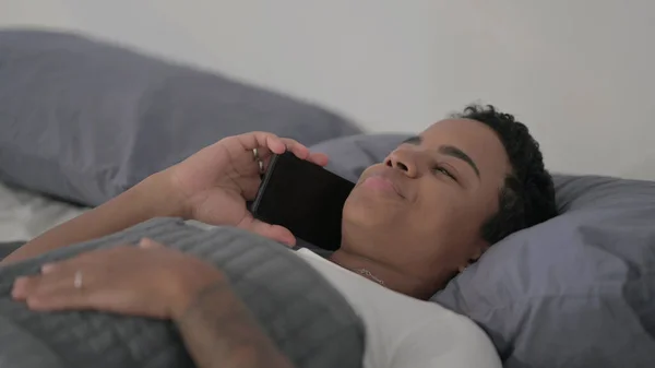Close African Woman Talking Smartphone While Laying Bed — Fotografia de Stock