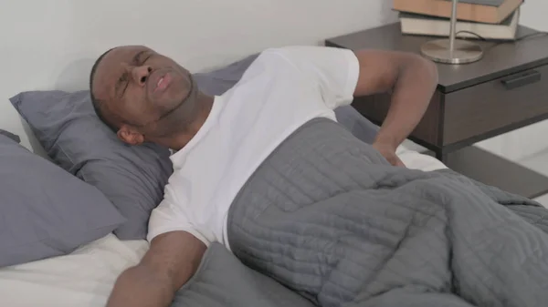 Young African Man Having Back Pain While Sleeping Bed — 스톡 사진