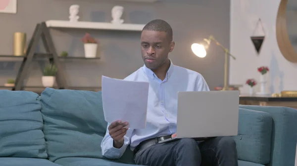 Young African Man Laptop Working Documents Sofa —  Fotos de Stock