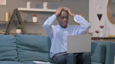 The Young African Man with Laptop Reacting to Loss on Documents, Sofa