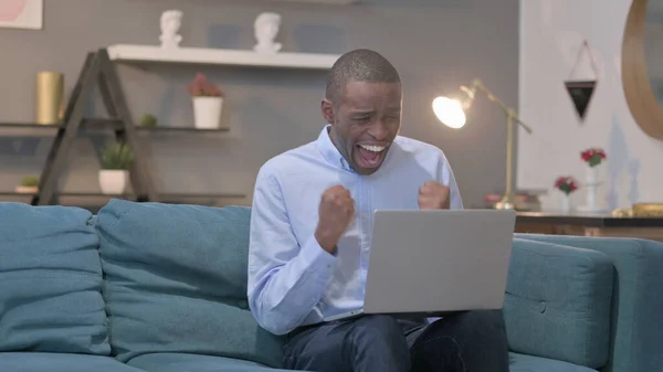 Young African Man Laptop Celebrating Success Sofa — Stockfoto