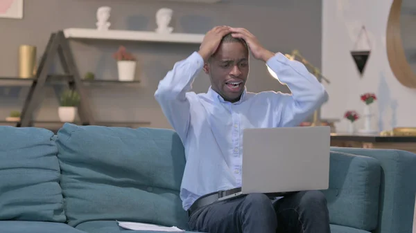 Young African Man Laptop Reacting Loss Documents Sofa — Stockfoto