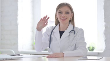 Kadın Doktor Klinikte otururken Videoda Konuşuyor