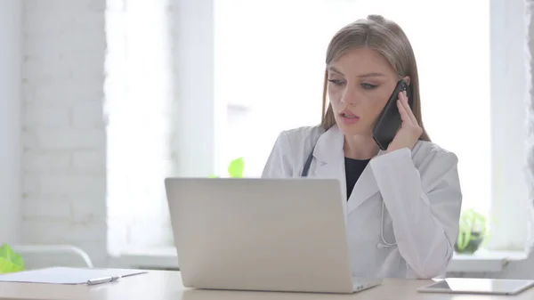 Kvinnlig Doktor Talar Telefon Medan Arbetar Laptop — Stockfoto