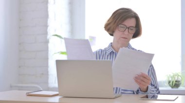 Ofiste otururken Yaşlı Kadın Haberleri Okuyor