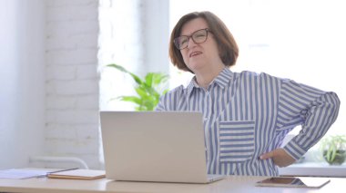 Laptop kullanırken Sırt Ağrısı Olan Yaşlı Kadın
