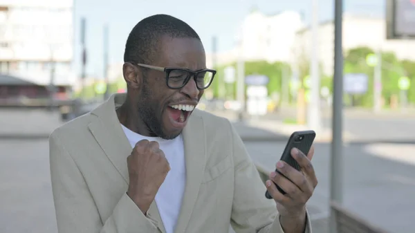 非裔美国人在智能手机室外庆祝在线成功 — 图库照片