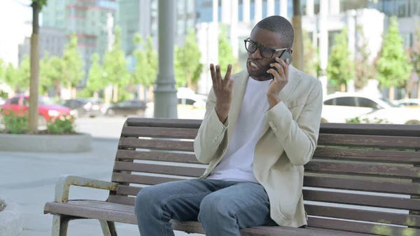 Kızgın Afrikalı Amerikalı Adam Bench Otururken Telefonla Konuşuyor — Stok fotoğraf