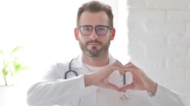 Orta yaşlı Doktor Kalp Şeklini Eller Tarafından Gösteriyor