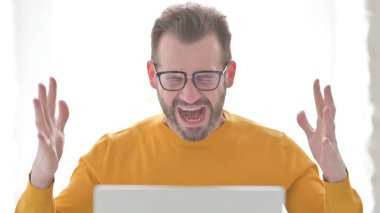 Middle Aged Man Shouting while using Laptop