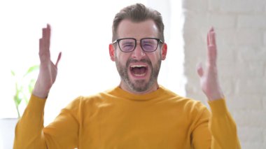 Orta yaşlı adam bağırıyor, çığlık atıyor.