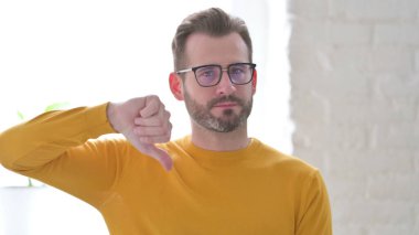 Orta Yaşlı Adam Başparmaklarını Aşağı Gösteriyor