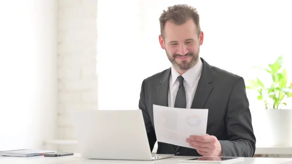 Empresario Con Computadora Portátil Celebrando Éxito Mientras Lee Documentos — Foto de Stock