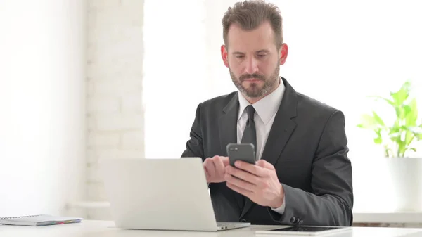 Homme Affaires Utilisant Smartphone Tout Utilisant Ordinateur Portable Dans Office — Photo