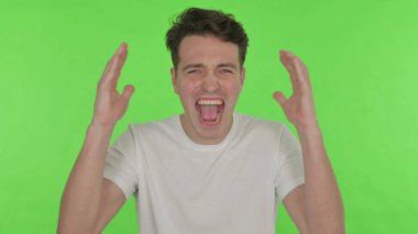 Yeşil Arkaplanda Bağrışan ve Bağıran Sıradan Genç Adam