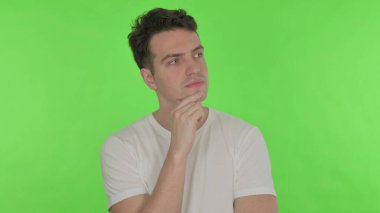 Yeşil Arkaplanda Yeni Bir Fikri Olan Sıradan Genç Adam Düşünüyor
